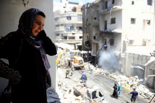 A woman inspects a damaged site after a suicide and car bomb attack in south Damascus Shi'ite suburb of Sayeda Zeinab, Syria June 11, 2016. REUTERS/Omar Sanadiki