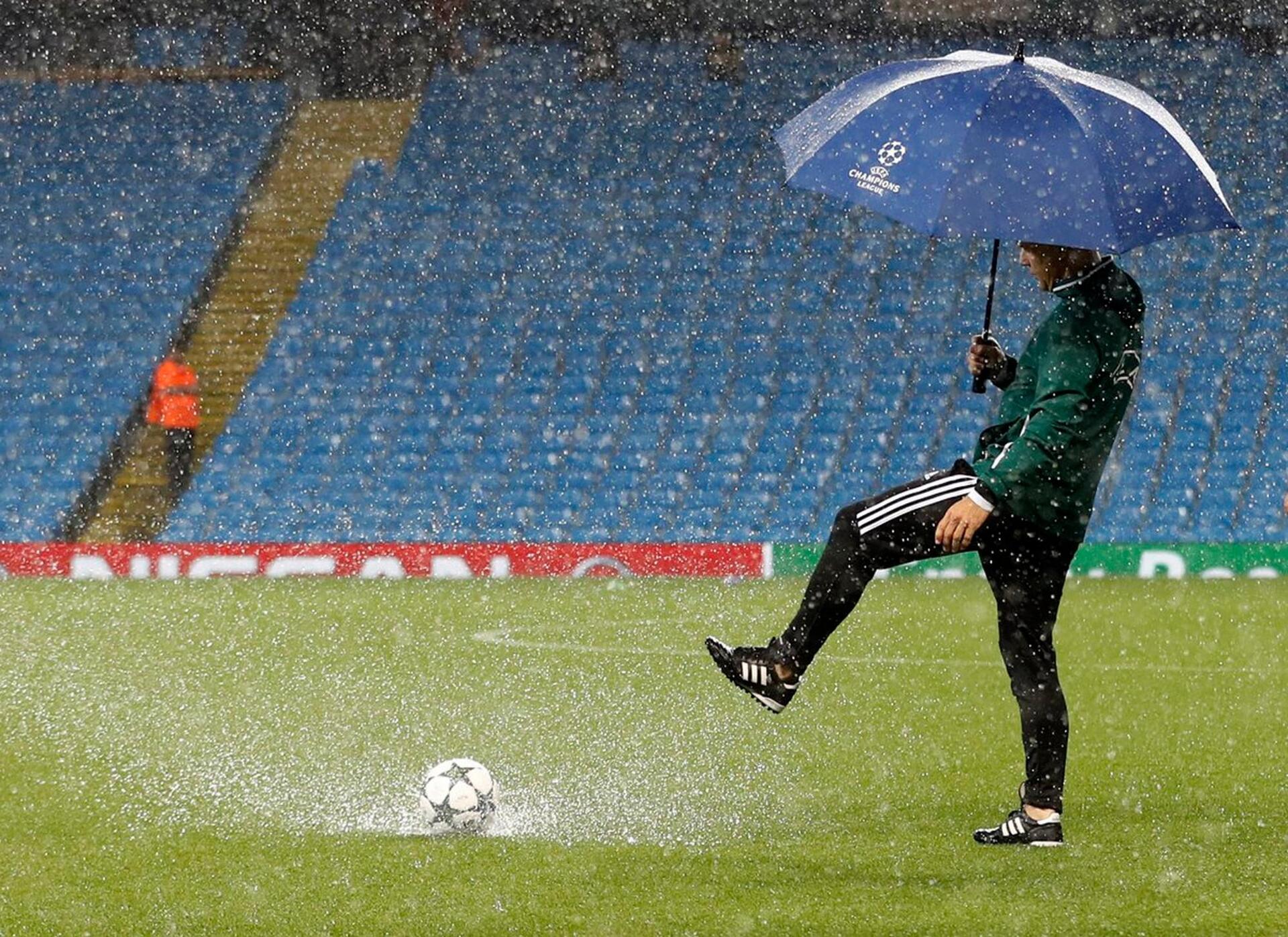 Вода на стадионе. Футбол под дождем. Футболист под дождем. Дождь на стадионе. Футбольное поле дождь.